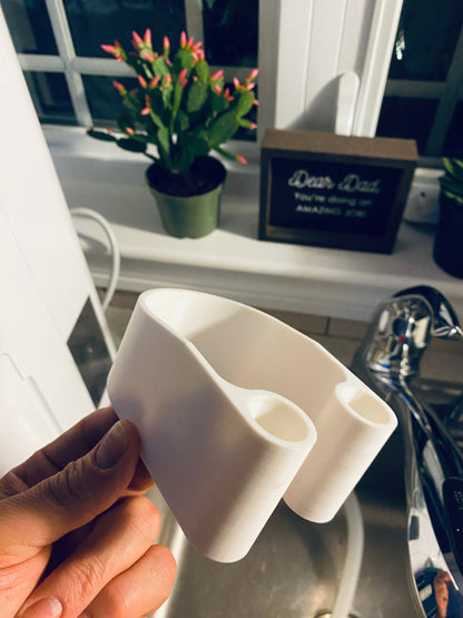 Hand holding 3D printed dehumidifier drain hose bracket showing shape and design

