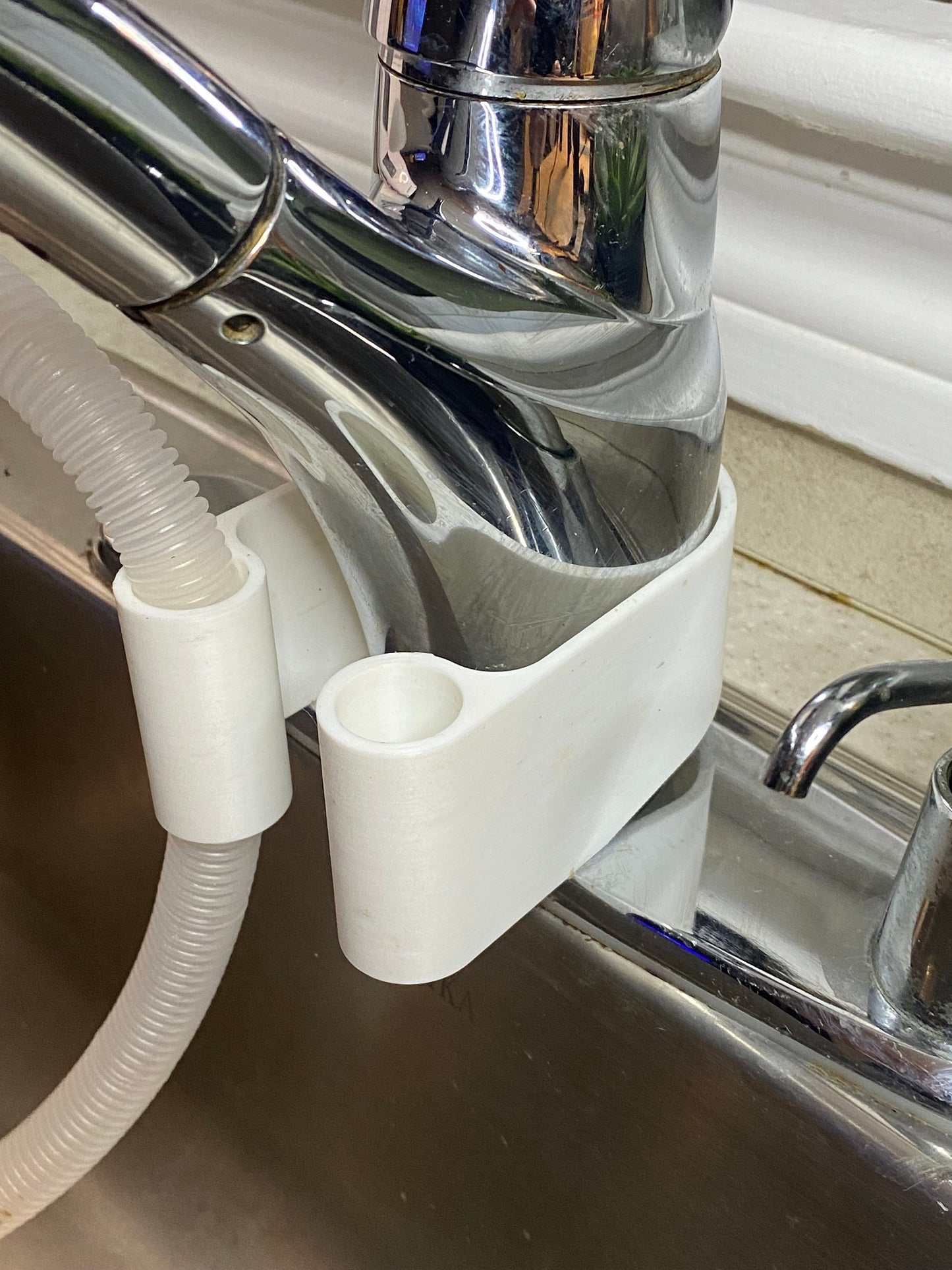 Dehumidifier drain hose bracket clipped onto kitchen sink faucet for easy drainage
