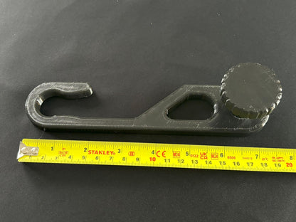 Standard-hook black shower caddy extension hanger showing shape and knob detail with Ruler for size refenence.