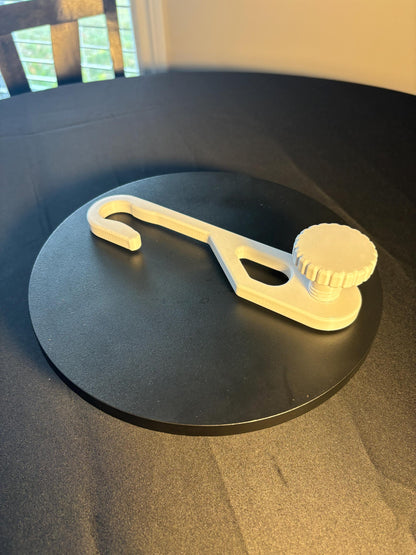 Standard-hook white shower caddy extension hanger with adjustment knob in studio lighting on black background Angle view.