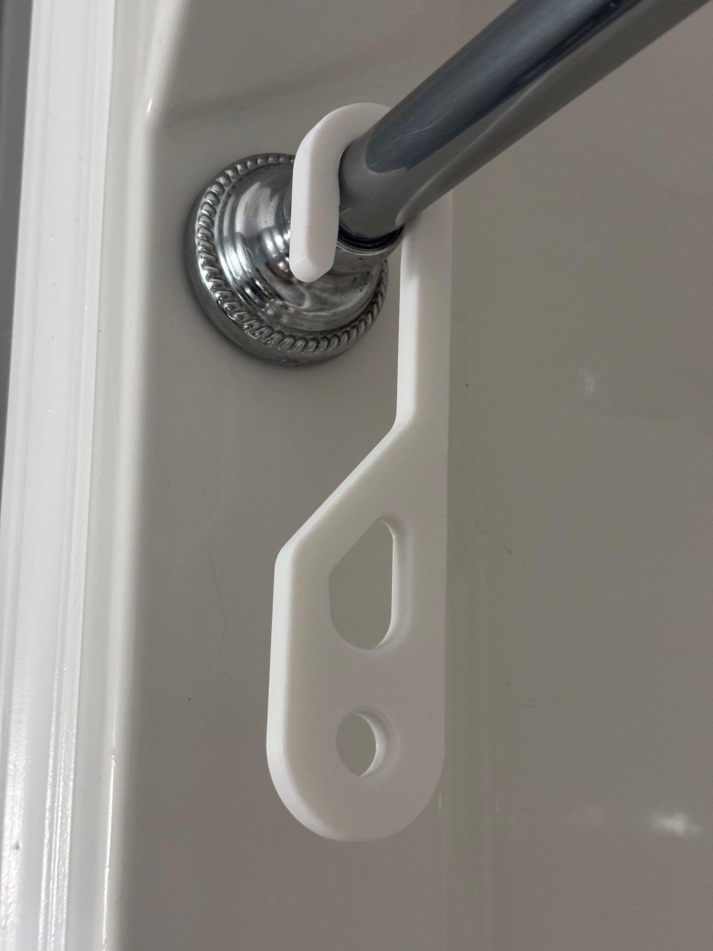 Wide-hook white shower caddy extension hanger installed on shower rod holding full-length hanging shower caddy