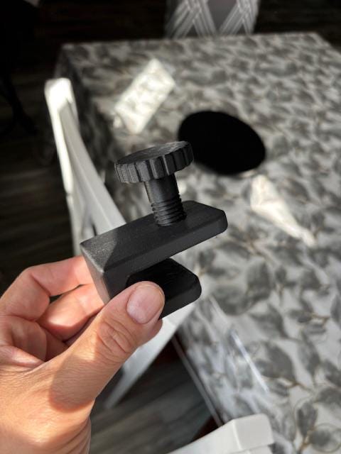 Close-up of black shower caddy adapter block with tightening knob