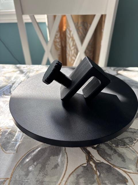 Standalone product photo of black shower caddy adapter block on display surface